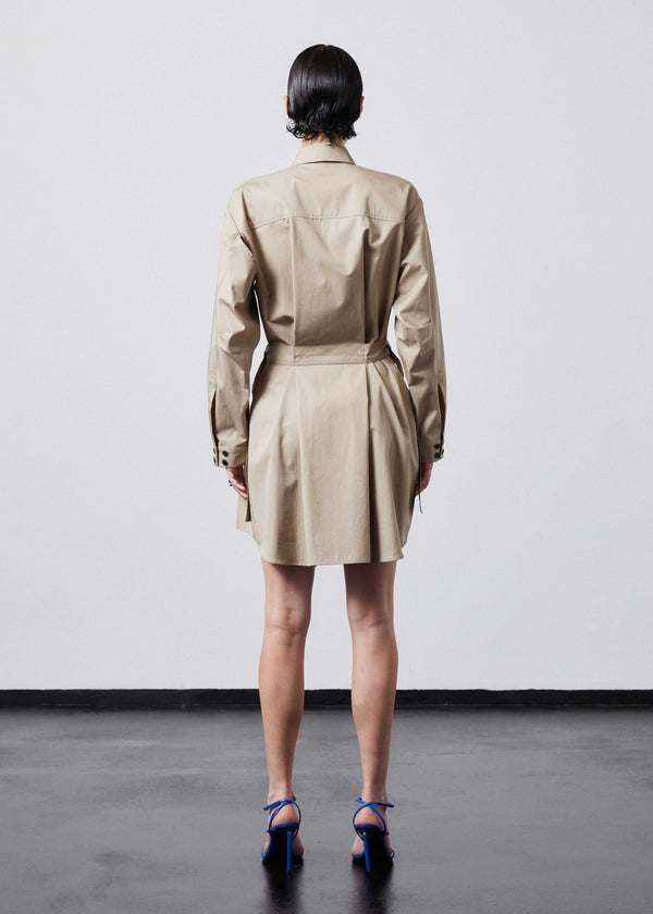 INTERNATIONAL CITIZEN.  Style: Artist Shirt Dress. Back view. Style has an oversized shirt with a pen pocket at the chest, open underarms for breathability, and back belt ties that adjust at the front with silver rings. The shirt are made of Italian organic Cotton Twill in Dune. Spiritually Infused, Sustainable Luxury Fashion in Berlin.