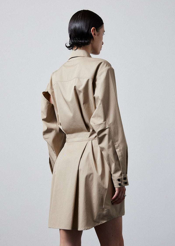 INTERNATIONAL CITIZEN.  Style: Artist Shirt Dress. Close up back view. Style has an oversized shirt with a pen pocket at the chest, open underarms for breathability, and back belt ties that adjust at the front with silver rings. The shirt are made of Italian organic Cotton Twill in Dune. Spiritually Infused, Sustainable Luxury Fashion in Berlin.