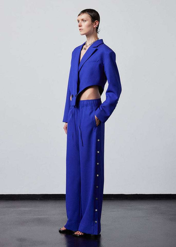 INTERNATIONAL CITIZEN.  Style: The French-Cut Jacket is oversized in the fit with a high french-cut hemline. Unisex item. Full body profile photo. Made of Italian Wool, Lapis Lazuli blue. Spiritually Infused, Sustainable Luxury Fashion in Berlin.