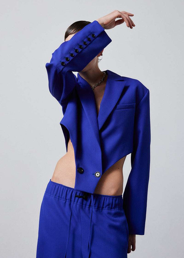 INTERNATIONAL CITIZEN.  Style: The French-Cut Jacket is oversized in the fit with a high french-cut hemline. Front detail photo. Unisex item. Made of Italian Wool, Lapis Lazuli blue. Spiritually Infused, Sustainable Luxury Fashion in Berlin.