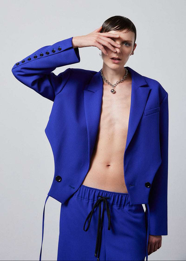 INTERNATIONAL CITIZEN.  Style: The French-Cut Jacket is oversized in the fit with a high french-cut hemline. Front photo worn open. Unisex item. Made of Italian Wool, Lapis Lazuli blue. Spiritually Infused, Sustainable Luxury Fashion in Berlin.