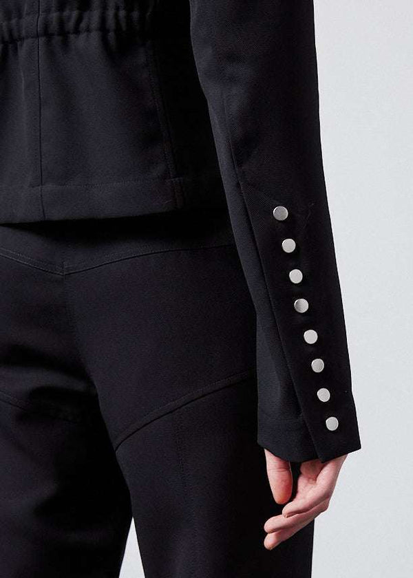 INTERNATIONAL CITIZEN.  Style: The Lunar Shacket is a slim jacket that wears like a shirt. It is lined with silver snaps sleeve vent. Close up sleeve button photo. Made of Italian Wool RWS, Obsidian Black. Spiritually Infused, Sustainable Luxury Fashion in Berlin.