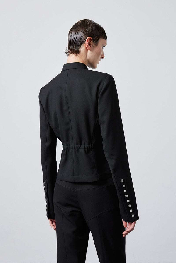 INTERNATIONAL CITIZEN.  Style: The Lunar Shacket is a slim jacket that wears like a shirt. It is lined with silver snaps down the front closure and sleeve vent. It has an elastic back waist. Back photo. Made of Italian Wool RWS, Obsidian Black. Spiritually Infused, Sustainable Luxury Fashion in Berlin.