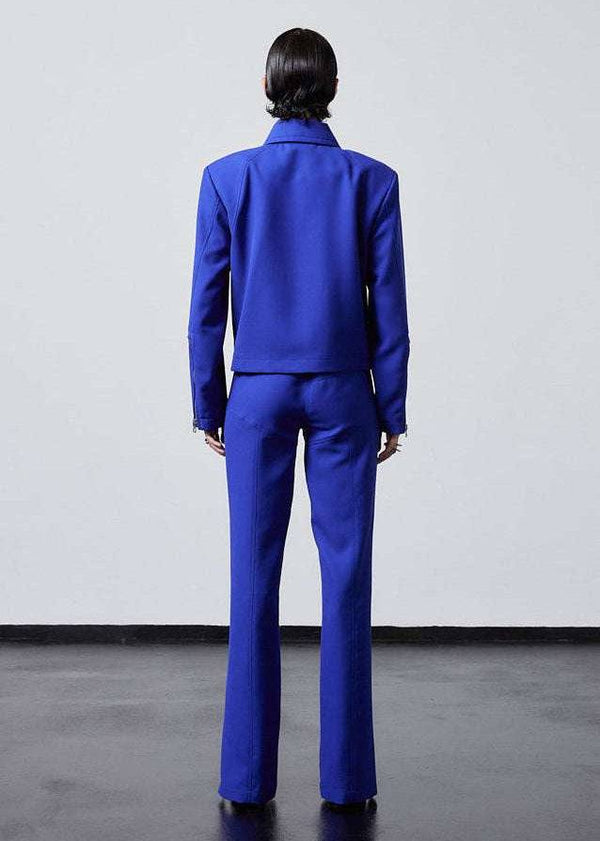 INTERNATIONAL CITIZEN.  Style: Ajna Jacket - a blue boxy jacket with sporty tailoring, featuring square shoulders, tapered sleeves, and zipper closures. The jacket is made from of Italian Wool in Lapis Lazuli Blue. Full body back view. Spiritually Infused, Sustainable Luxury Fashion in Berlin.