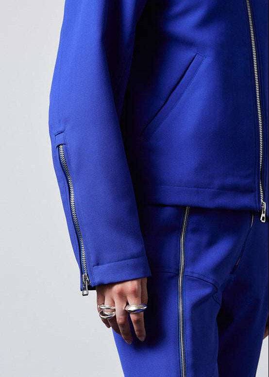 INTERNATIONAL CITIZEN.  Style: Ajna Jacket - a blue boxy jacket with sporty tailoring. Close up photo of the sleeve zipper closure. The jacket is made from of Italian Wool in Lapis Lazuli Blue. Spiritually Infused, Sustainable Luxury Fashion in Berlin.