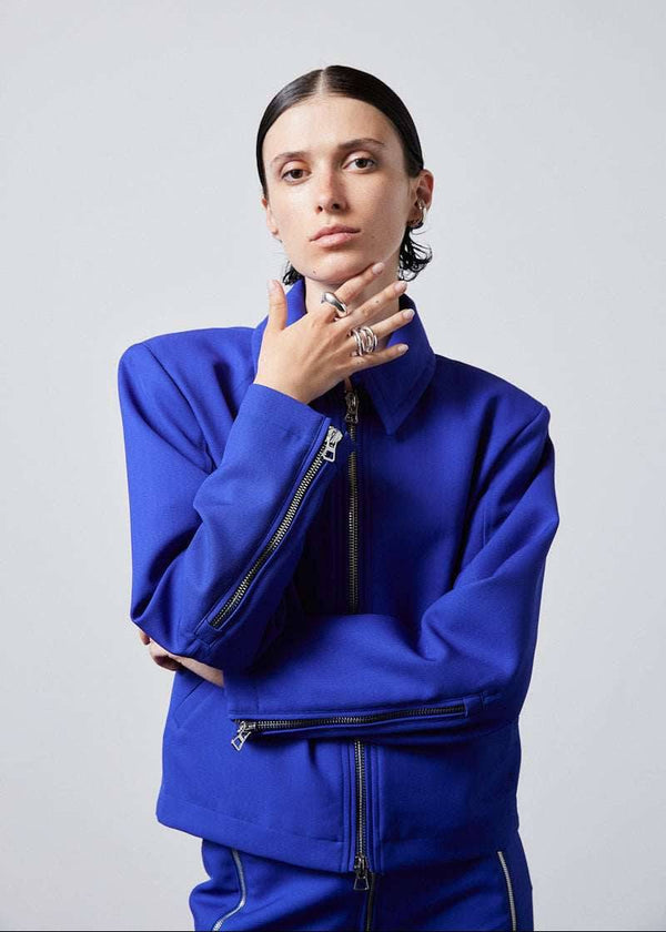 INTERNATIONAL CITIZEN.  Style: Ajna Jacket - a blue boxy jacket with sporty tailoring, featuring square shoulders, tapered sleeves, and zipper closures. The jacket is made from of Italian Wool in Lapis Lazuli Blue. Spiritually Infused, Sustainable Luxury Fashion in Berlin.