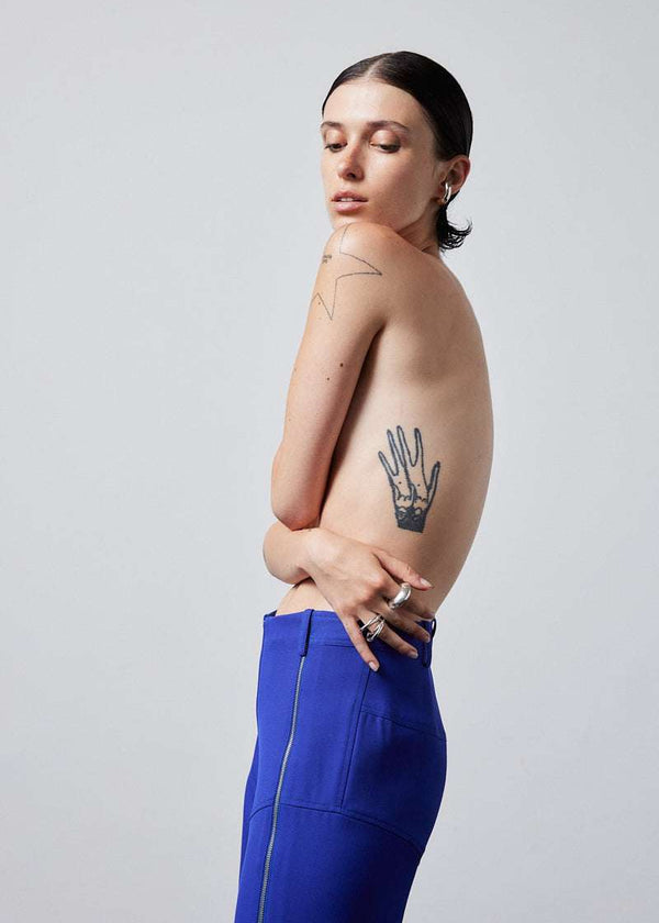 INTERNATIONAL CITIZEN.  Style: The Racer Pants. Made of Italian Wool RWS, Lapis Lazuli Blue. Spiritually Infused, Sustainable Luxury Fashion in Berlin. Close up side photo.
