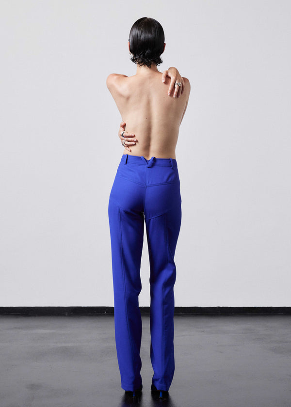 INTERNATIONAL CITIZEN.  Style: The Racer Pants have zippers down the entire front legs from the waistband to the hemline and a fly front zip. Made of Italian Wool RWS, Lapis Lazuli Blue. Spiritually Infused, Sustainable Luxury Fashion in Berlin. Full body back photo.