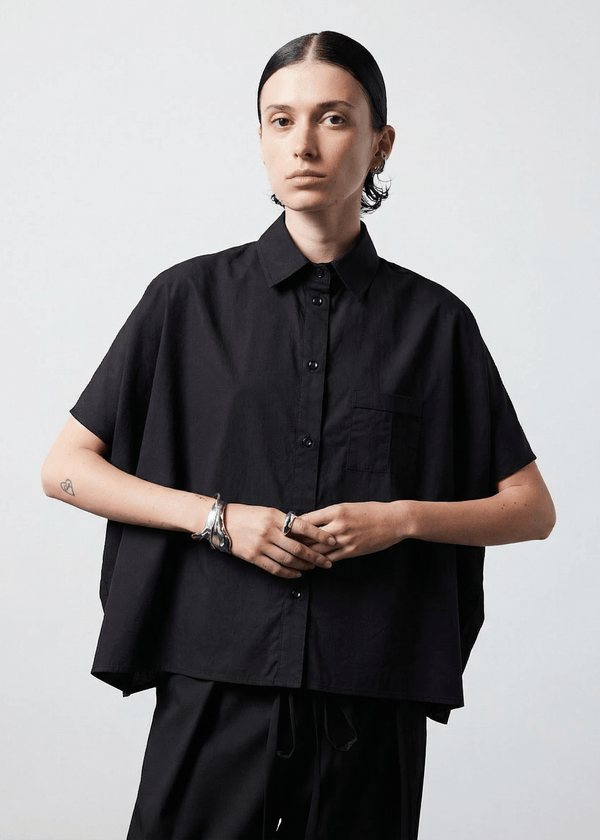 INTERNATIONAL CITIZEN.  Style: The Cubism Shirt is a 3-dimensional cube tilted on its axes to create a boxy minimal front body and dramatic drape in the back body and a utility pen pocket on the chest. Unisex Item. Made of Italian Organic Cotton, Obsidian Black. Spiritually Infused, Sustainable Luxury Fashion in Berlin.