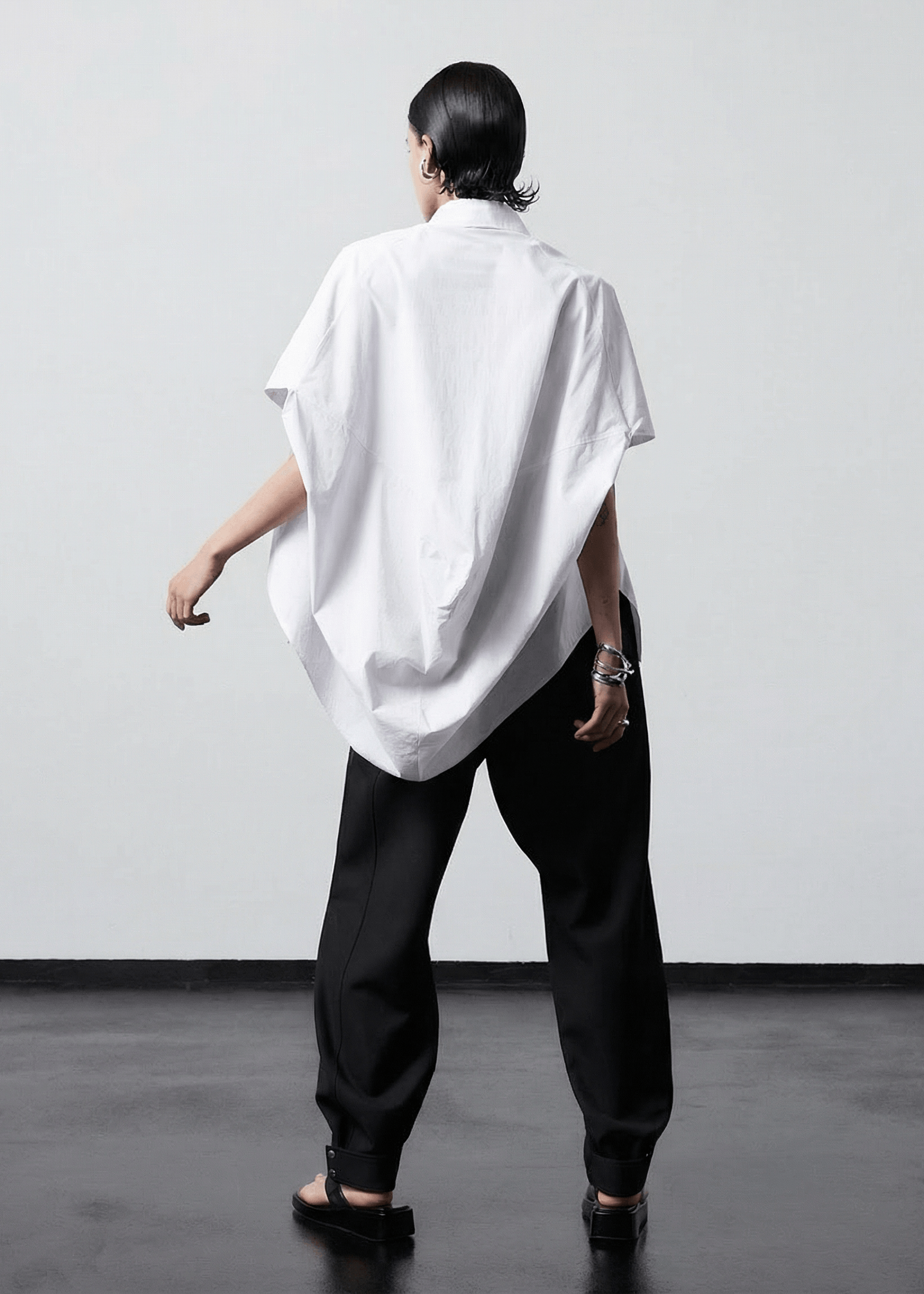 INTERNATIONAL CITIZEN.  Style: The Cubism Shirt is a 3-dimensional cube tilted on its axes to create dramatic drape in the back body. Back view. Unisex Item. Made of Italian Organic Cotton, White Quartz. Spiritually Infused, Sustainable Luxury Fashion in Berlin.