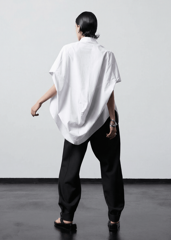 INTERNATIONAL CITIZEN.  Style: The Cubism Shirt is a 3-dimensional cube tilted on its axes to create dramatic drape in the back body. Back view. Unisex Item. Made of Italian Organic Cotton, White Quartz. Spiritually Infused, Sustainable Luxury Fashion in Berlin.