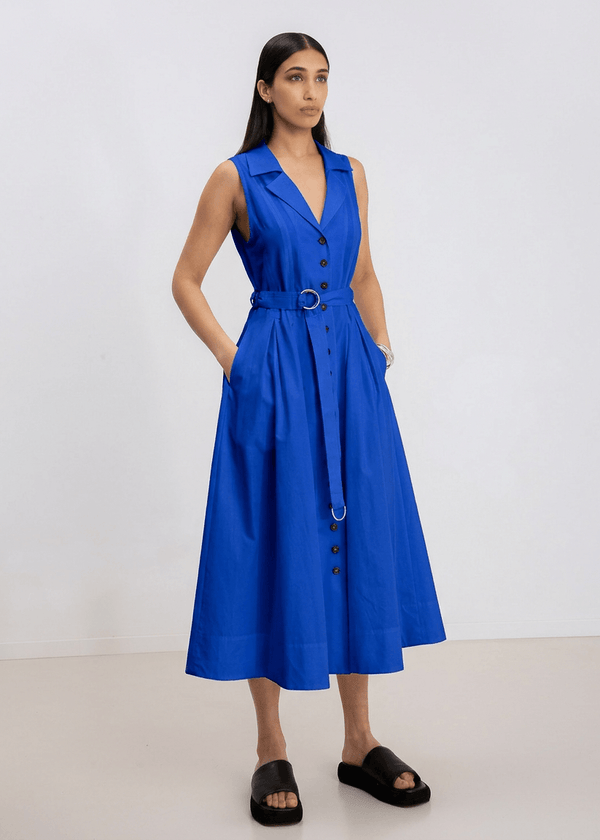 INTERNATIONAL CITIZEN.  Style: Button Dress. A Button Dress with princess seams that open to box pleats below the hips. Detachable belt with silver ring details for closure. The dress is made of Italian organic Cotton in Lapis Lazuli. Spiritually Infused, Sustainable Luxury Fashion in Berlin.