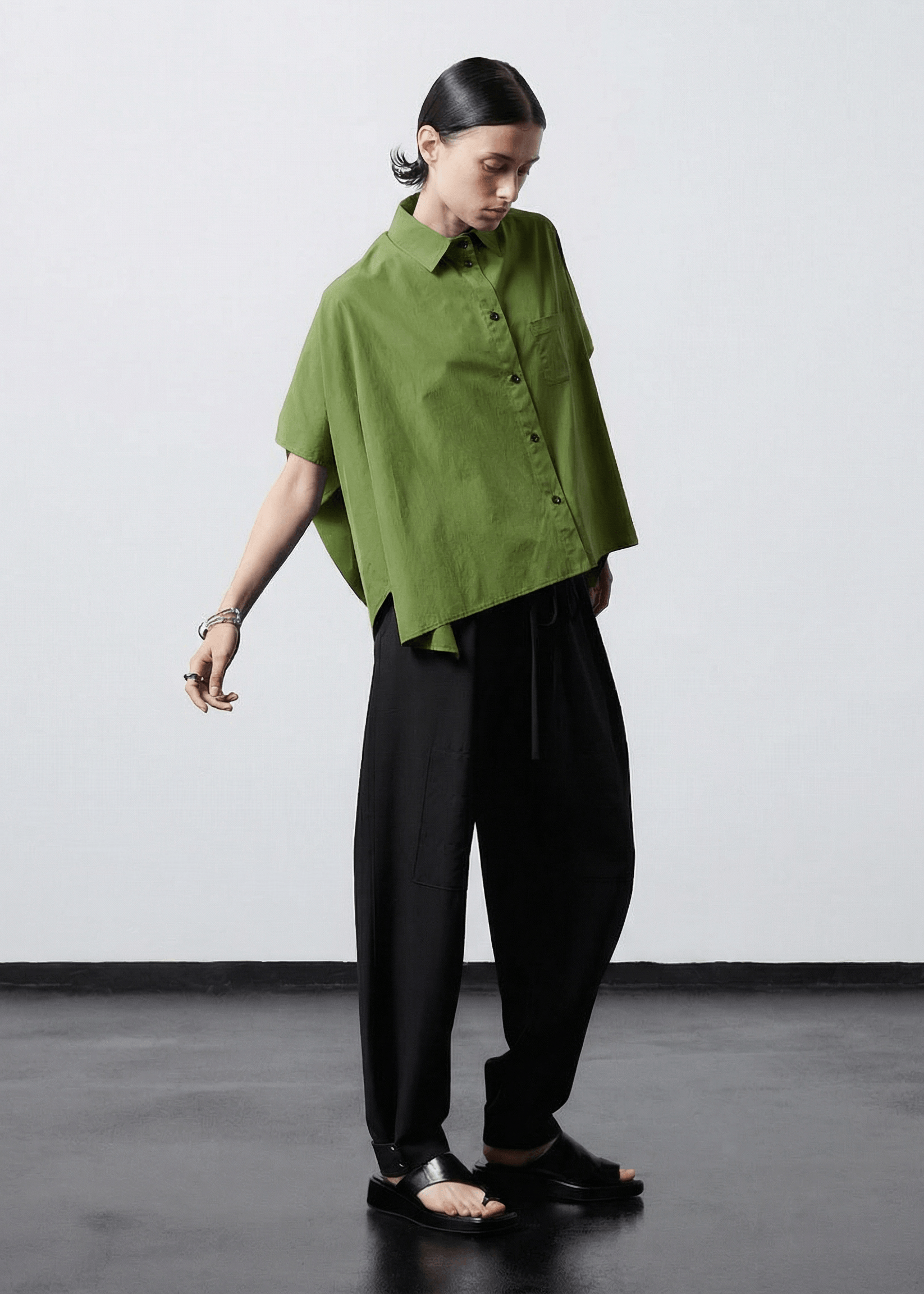 INTERNATIONAL CITIZEN.  Style: The Cubism Shirt is a 3-dimensional cube tilted on its axes to create a boxy minimal front body and dramatic drape in the back body. Full body view. Unisex Item. Made of Italian Organic Cotton,Nephrite Jade Green. Spiritually Infused, Sustainable Luxury Fashion in Berlin.