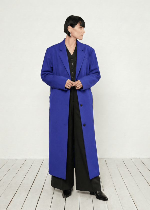 INTERNATIONAL CITIZEN.  Style: Duster Coat. A unisex coat that features traditional men's tailoring construction details. The coat is made of Italian RWS Wool in Lapis Lazuli Blue. Spiritually Infused, Sustainable Luxury Fashion in Berlin.