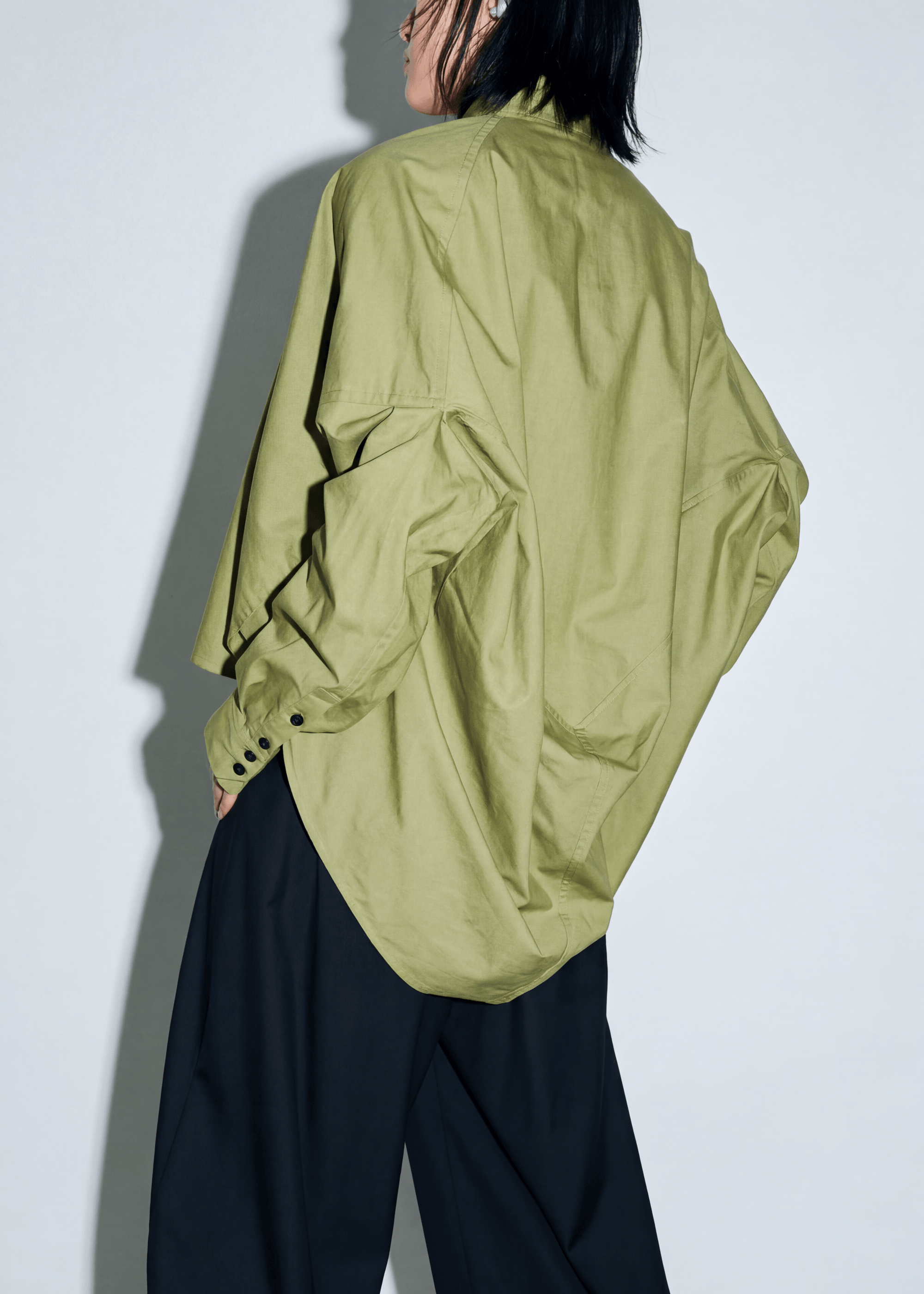 INTERNATIONAL CITIZEN.  Style: The Cubism Shirt is a 3-dimensional cube tilted on its axes to create a boxy minimal dramatic drape in the back body. Unisex Item. Made of Italian Organic Cotton,Nephrite Jade Green. Spiritually Infused, Sustainable Luxury Fashion in Berlin.