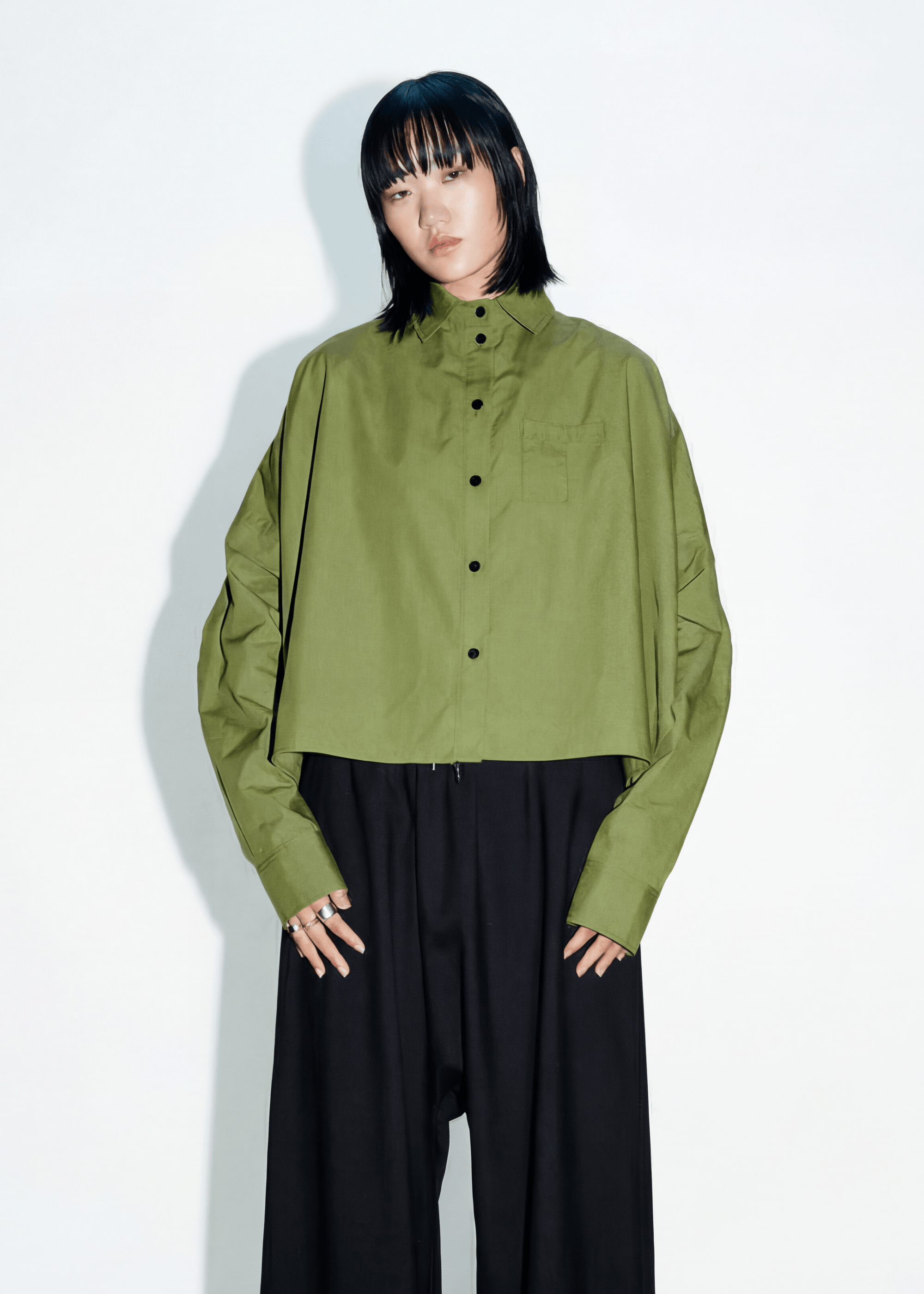 INTERNATIONAL CITIZEN.  Style: The Cubism Shirt is a 3-dimensional cube tilted on its axes to create a boxy minimal front body and dramatic drape in the back body and a utility pen pocket on the chest. Unisex Item. Made of Italian Organic Cotton,Nephrite Jade Green. Spiritually Infused, Sustainable Luxury Fashion in Berlin.