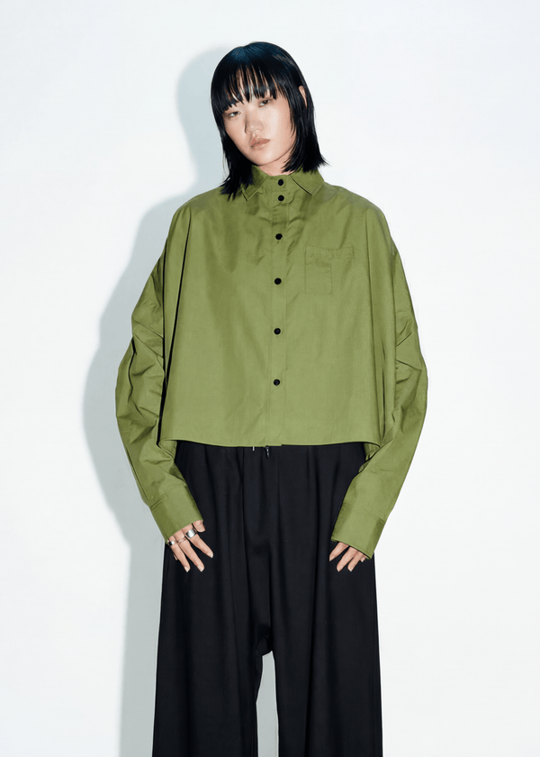 INTERNATIONAL CITIZEN.  Style: The Cubism Shirt is a 3-dimensional cube tilted on its axes to create a boxy minimal front body and dramatic drape in the back body and a utility pen pocket on the chest. Unisex Item. Made of Italian Organic Cotton,Nephrite Jade Green. Spiritually Infused, Sustainable Luxury Fashion in Berlin.