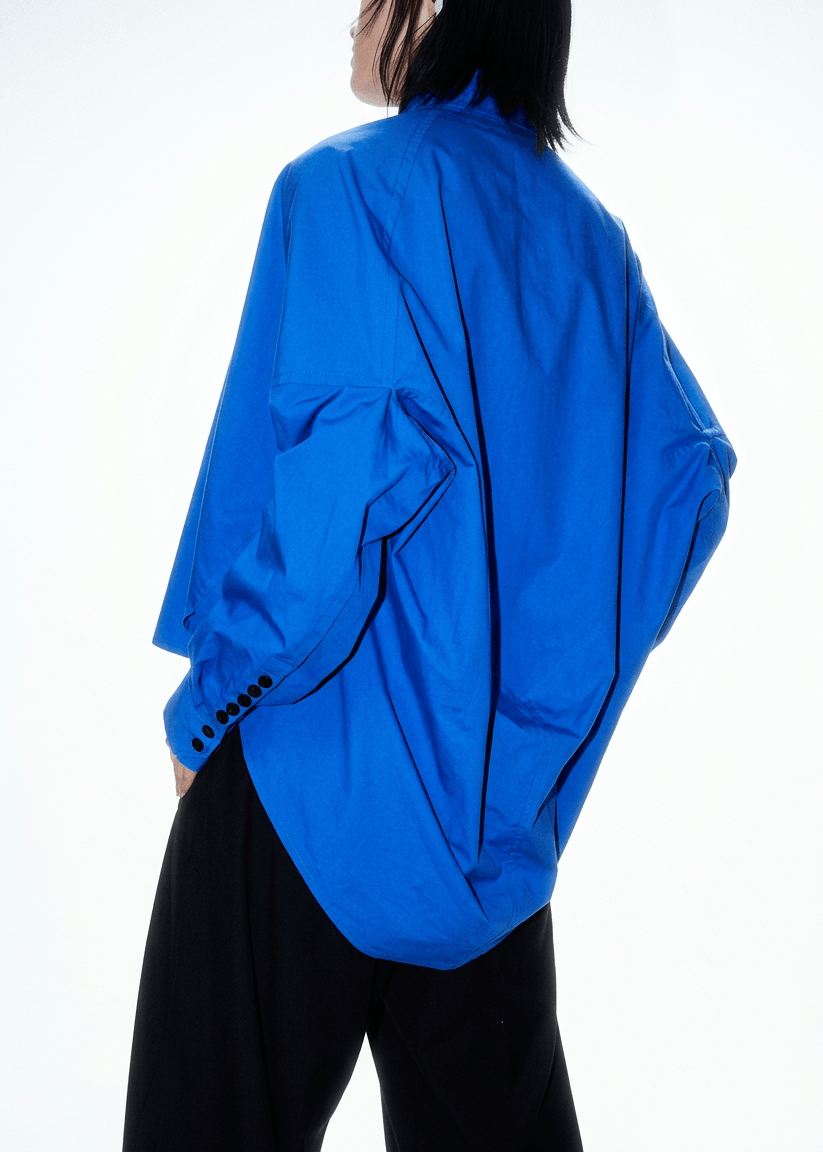 INTERNATIONAL CITIZEN.  Style: The Cubism Shirt is a 3-dimensional cube tilted on its axes to create a boxy minimal and dramatic drape in the back body. Unisex Item. Made of Italian Organic Cotton, Lapis Lazuli Blue. Spiritually Infused, Sustainable Luxury Fashion in Berlin.