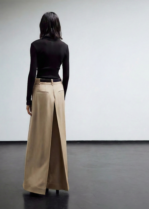 INTERNATIONAL CITIZEN.  Style: The Deep Pleated Pant, falls below the natural waist. The pleats meet at the center back. Side back. Made of Italian Organic Cotton, Dune. Spiritually Infused, Sustainable Luxury Fashion in Berlin.