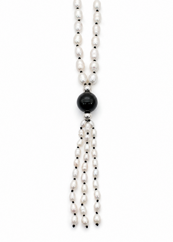 Close-up photo of the Leuce Necklace pendant tassle. Made of genuine river pearls and obsidian center bead.