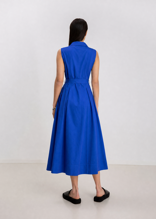 INTERNATIONAL CITIZEN.  Style: Button Dress. A Button Dress with princess seams that open to box pleats below the hips. Back view. The dress is made of Italian organic Cotton in Lapis Lazuli. Spiritually Infused, Sustainable Luxury Fashion in Berlin.