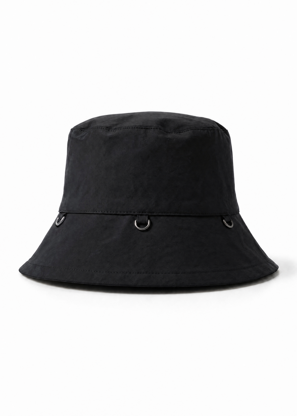 INTERNATIONAL CITIZEN.  Style: The Charm Bucket Hat. Front view. A unisex hat with utility details that feature our signature silver ring at the back and mini rings around the rim to clip your charms. Made of Italian post-consumer recycled Nylon, Obsidian Black. Spiritually Infused, Sustainable Luxury Fashion in Berlin.