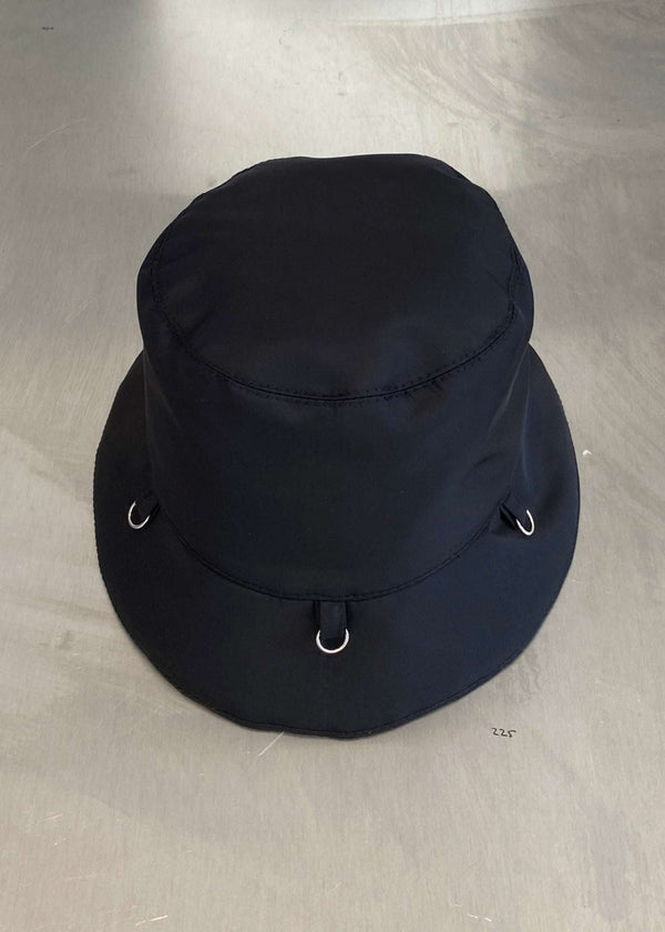 INTERNATIONAL CITIZEN.  Style: The Charm Bucket Hat. Front view. A unisex hat with utility details that feature our signature silver ring at the back and mini rings around the rim to clip your charms. Made of Italian post-consumer recycled Nylon, Obsidian Black. Spiritually Infused, Sustainable Luxury Fashion in Berlin.