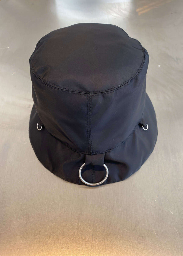 INTERNATIONAL CITIZEN.  Style: The Charm Bucket Hat. Back view. A unisex hat with utility details that feature our signature silver ring at the back and mini rings around the rim to clip your charms. Made of Italian post-consumer recycled Nylon, Obsidian Black. Spiritually Infused, Sustainable Luxury Fashion in Berlin.