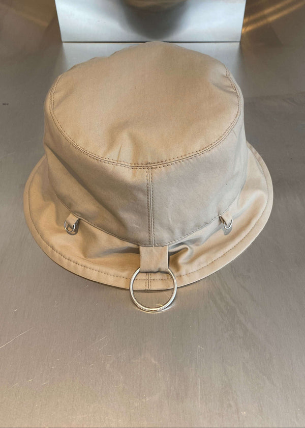 INTERNATIONAL CITIZEN.  Style: The Charm Bucket Hat. Back view. A unisex hat with utility details that feature our signature silver ring at the back and mini rings around the rim to clip your charms.  Made of Italian Organic Cotton Twill, Dune. Spiritually Infused, Sustainable Luxury Fashion in Berlin.
