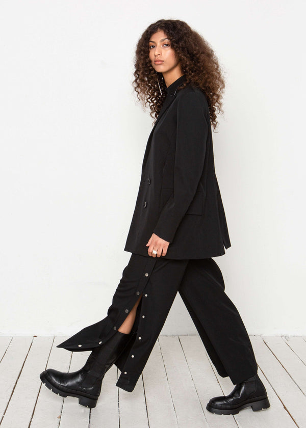 INTERNATIONAL CITIZEN.  Style: The Heart Opener Jacket features. Full body profile view. Made of Italian Wool, certified (RWS) Responsible Wool Standard, Obsidian Black. Spiritually Infused, Sustainable Luxury Fashion in Berlin.