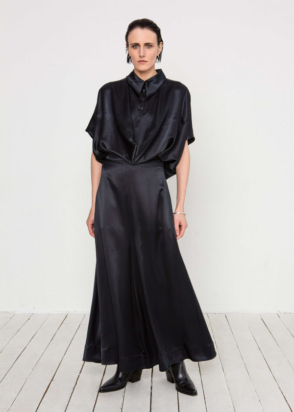INTERNATIONAL CITIZEN.  Style: Prism Top, using sacred geometry of a 3-dimensional prism falling over the body in a soft cowl drape with an origami folded collar at the front placket. Made of Organic Silk, Obsidian Black. Spiritually Infused, Sustainable Luxury Fashion in Berlin. Full body front photo.