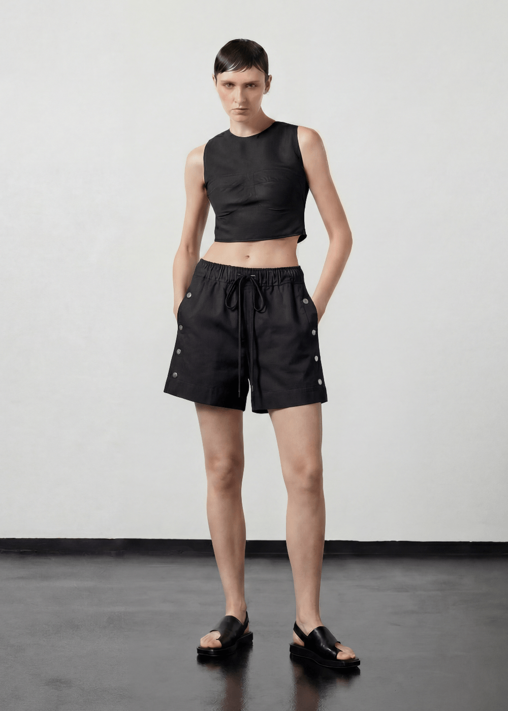 INTERNATIONAL CITIZEN.  Style: The Track Short has a smooth back waistband and elastic front with a drawcord tunnel at the front. Silver metal snaps down the side and mid thigh length. Unisex item. Made of Italian recycled Nylon, Obsidian Black. Spiritually Infused, Sustainable Luxury Fashion in Berlin.