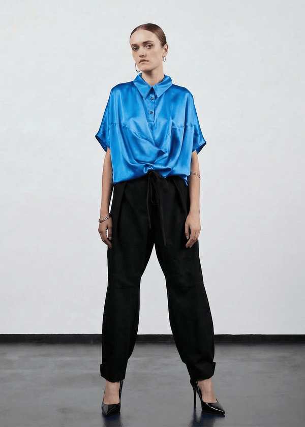 INTERNATIONAL CITIZEN.  Style: Prism Top, using sacred geometry of a 3-dimensional prism falling over the body in a soft cowl drape. Full body front view. Made of Organic Silk, Azurite Blue. Spiritually Infused, Sustainable Luxury Fashion in Berlin.