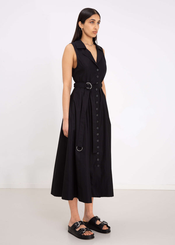 INTERNATIONAL CITIZEN.  Style: Button Dress. Side front view. A Button Dress with princess seams that open to box pleats below the hips. Detachable belt with silver ring details for closure. The dress is made of Italian organic Cotton in Obsidian Black. Spiritually Infused, Sustainable Luxury Fashion in Berlin.