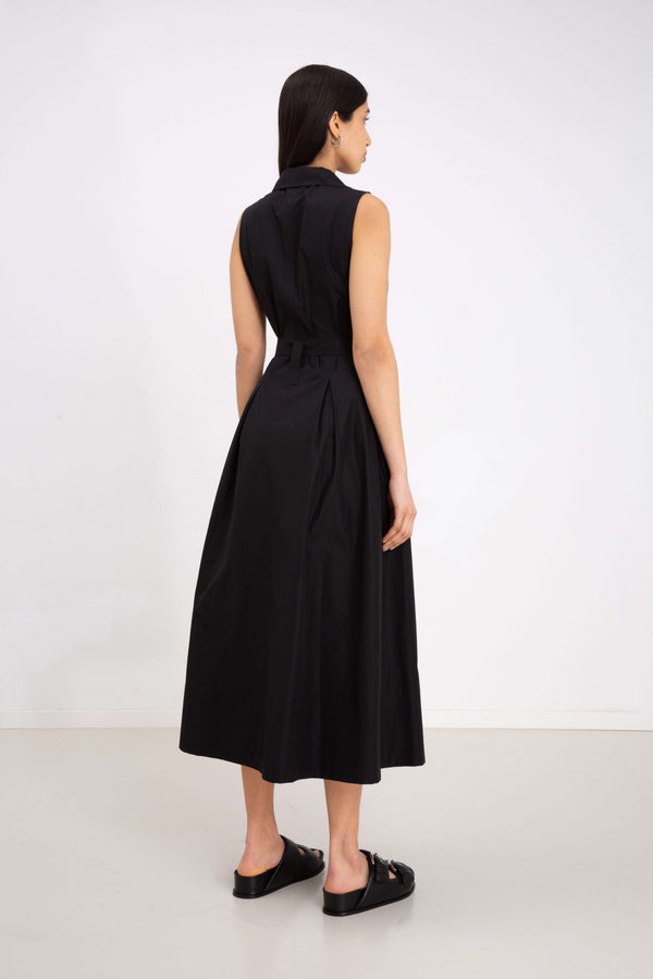 INTERNATIONAL CITIZEN.  Style: Button Dress. Side back view. A Button Dress with princess seams that open to box pleats below the hips. The dress is made of Italian organic Cotton in Obsidian Black. Spiritually Infused, Sustainable Luxury Fashion in Berlin.