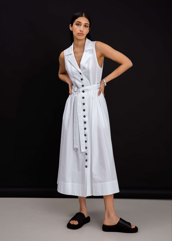 INTERNATIONAL CITIZEN.  Style: Button Dress. Front full body. A Button Dress with princess seams that open to box pleats below the hips. Detachable belt with silver ring details for closure. The dress is made of Italian organic Cotton in White Quartz. Spiritually Infused, Sustainable Luxury Fashion in Berlin.