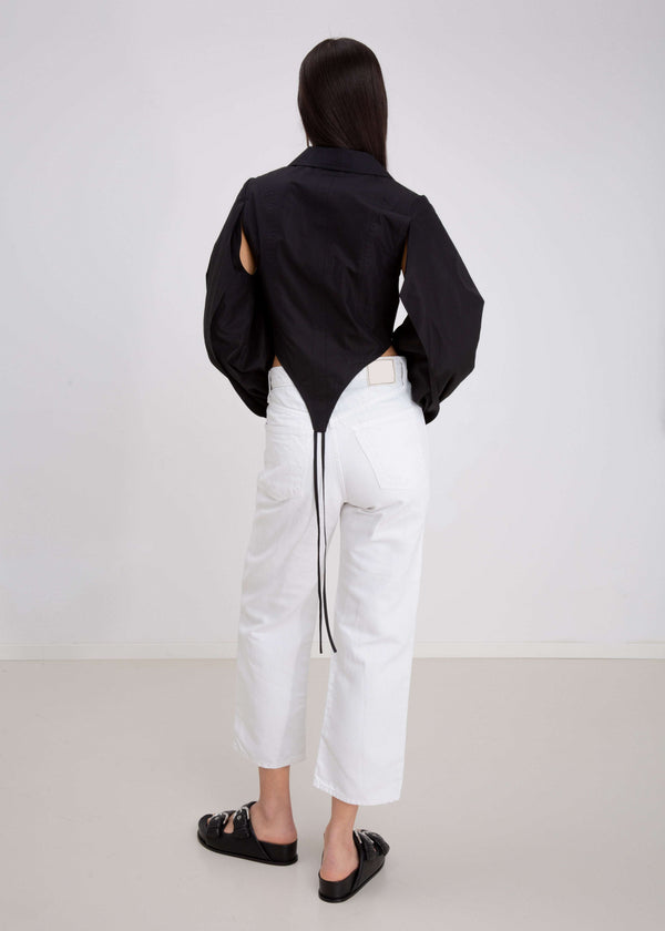 INTERNATIONAL CITIZEN.  Style: A French Cut Button Bodysuit with tie closures. It features exaggerated sleeve volume. Full body back view. Made of Italian Organic Cotton, Obsidian Black. Spiritually Infused, Sustainable Luxury Fashion in Berlin.