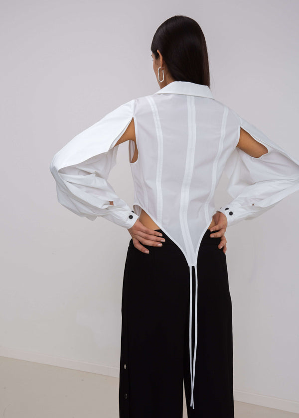INTERNATIONAL CITIZEN.  Style: A French Cut Button Bodysuit with tie closures. It features exaggerated sleeve volume pleated at the cuffs, with an open under arm for breathability. Close up back view. Made of Italian Organic Cotton, White Quartz. Spiritually Infused, Sustainable Luxury Fashion in Berlin.