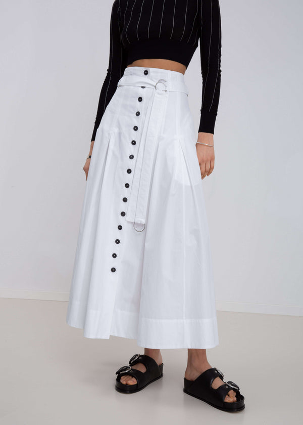 INTERNATIONAL CITIZEN.  Style: Button Skirt.  Close up front view. A Button Skirt with box pleats below the hips. Detachable belt with silver ring details for closure. The skirt is made of Italian organic Cotton in White Quartz. Spiritually Infused, Sustainable Luxury Fashion in Berlin.