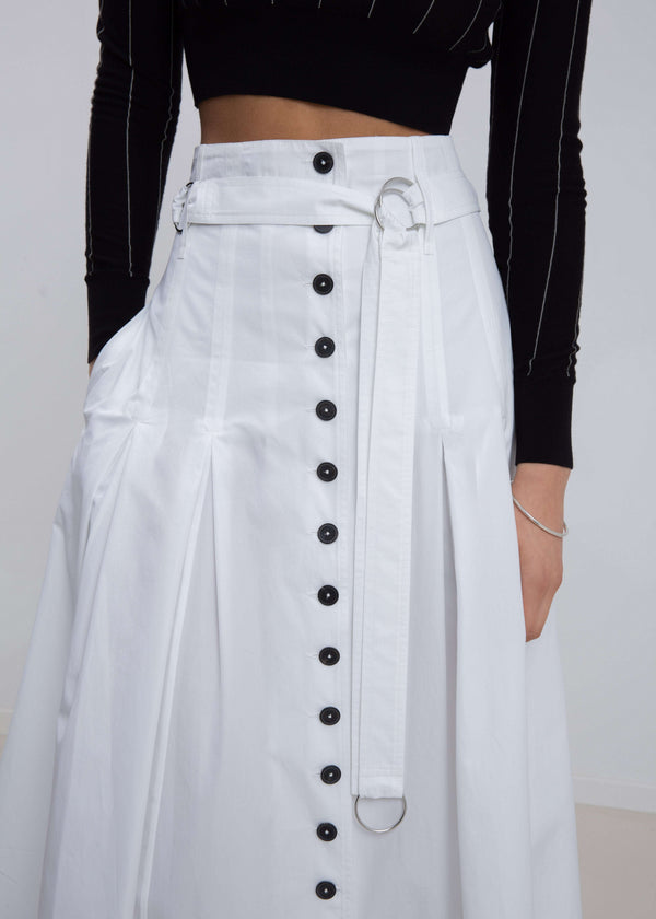 INTERNATIONAL CITIZEN.  Style: Button Skirt.  Close up view of belt. A Button Skirt with box pleats below the hips. Detachable belt with silver ring details for closure. The skirt is made of Italian organic Cotton in White Quartz. Spiritually Infused, Sustainable Luxury Fashion in Berlin.