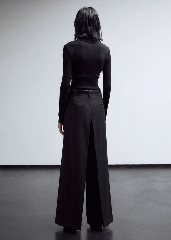 INTERNATIONAL CITIZEN.  Style: The Deep Pleated Pant, falls below the natural waist. The pleats meet at the center back. Made of Italian RWS Wool, Obsidian Black Purple. Spiritually Infused, Sustainable Luxury Fashion in Berlin.