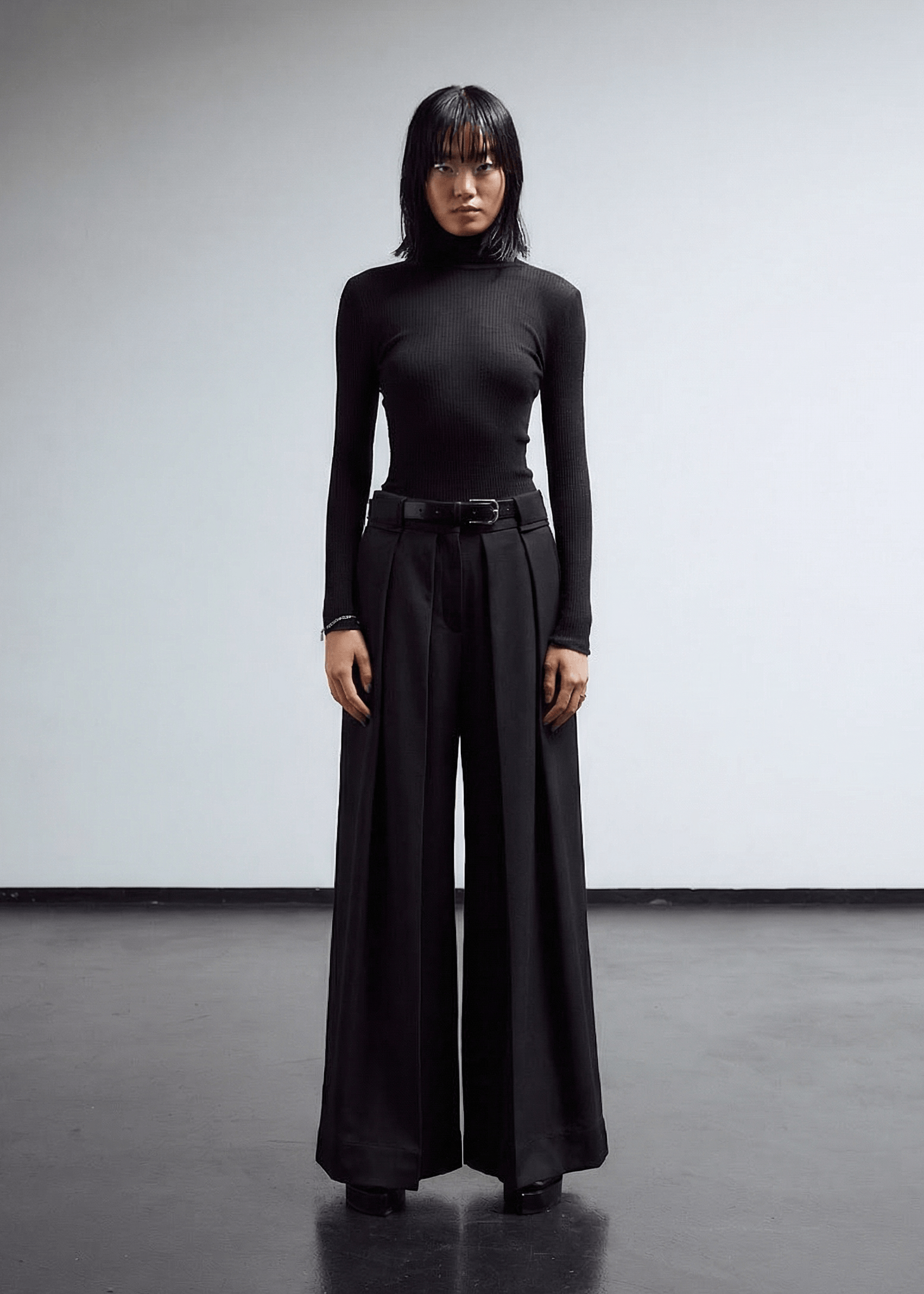 INTERNATIONAL CITIZEN.  Style: The Deep Pleated Pant, falls below the natural waist. The pleats nearly meet at the center front and at the center back. Made of Italian RWS Wool, Obsidian Black Purple. Spiritually Infused, Sustainable Luxury Fashion in Berlin.