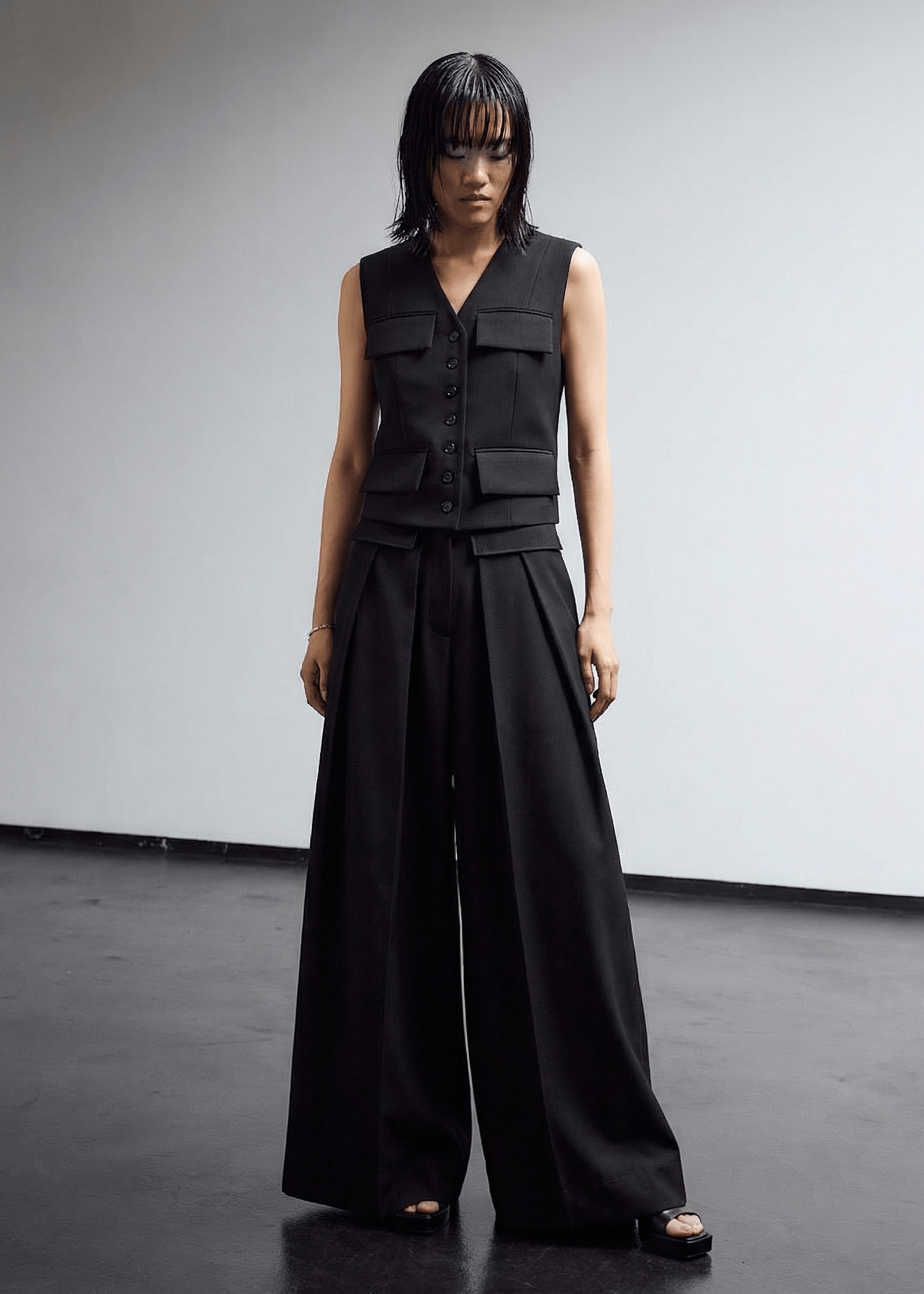 INTERNATIONAL CITIZEN.  Style: The Deep Pleated Pant, falls below the natural waist. Full front photo. Made of Italian RWS Wool, Obsidian Black Purple. Spiritually Infused, Sustainable Luxury Fashion in Berlin.