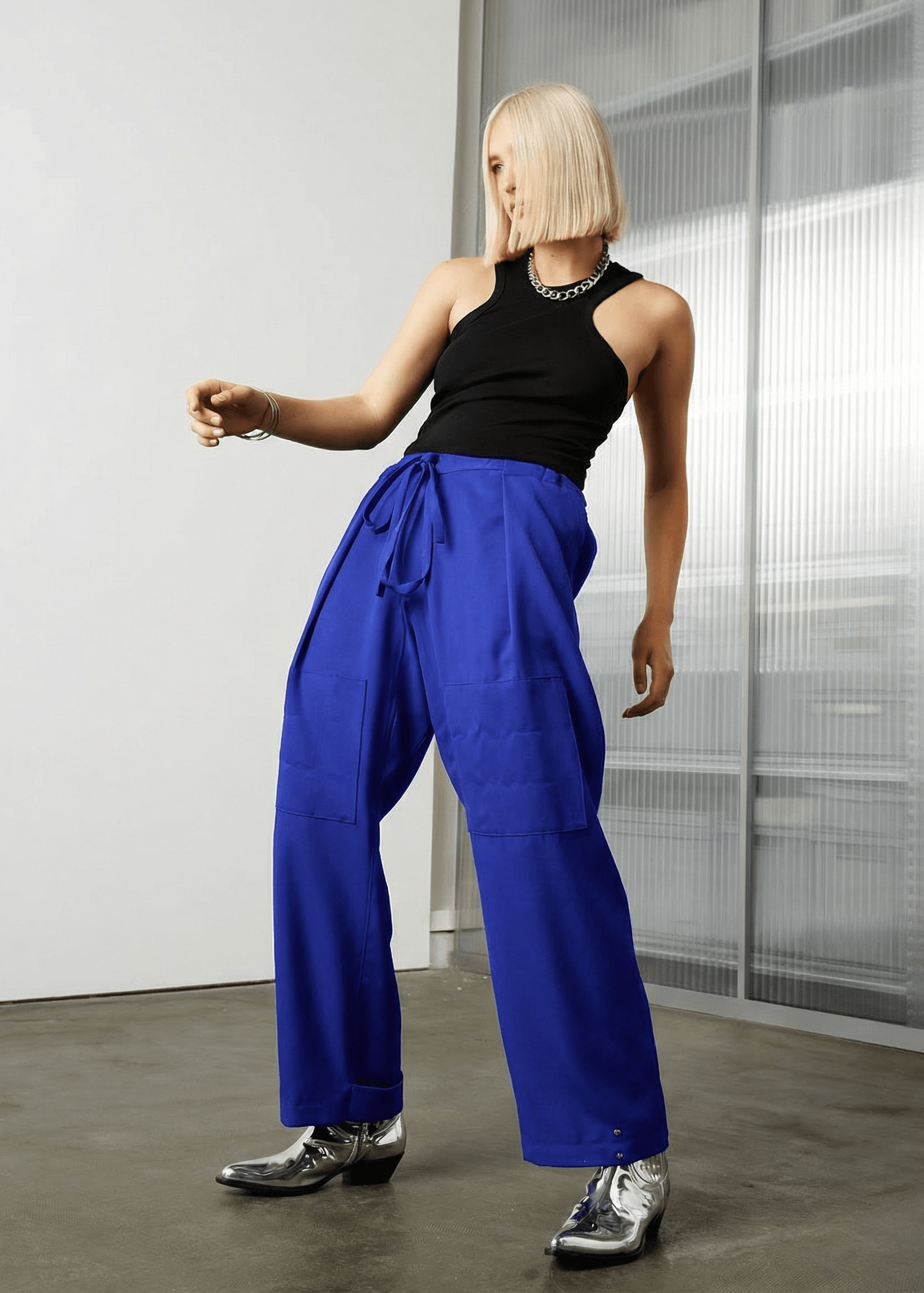 INTERNATIONAL CITIZEN.  Style: The JiuJitsu Pants are have a drawstring closer at the waist, a straight leg with silver snap hem straps and a thigh patch. Unisex item. Made of Italian Wool, certified (RWS) Responsible Wool Standard, Lapis Lazuli Blue. Spiritually Infused, Sustainable Luxury Fashion in Berlin.
